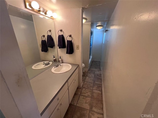 bathroom with toilet, tile patterned floors, walk in shower, and vanity