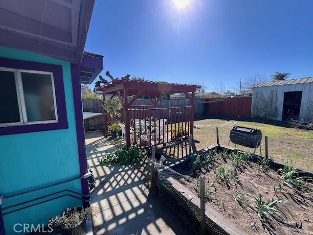 view of patio / terrace featuring an outdoor structure, a fenced backyard, and a pergola