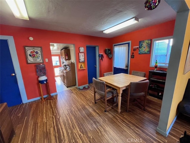 dining area with plenty of natural light, a textured ceiling, and wood finished floors