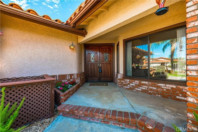 30220 Skippers Way Dr, Canyon Lake, CA 92587 - doorway to property with a patio, brick siding, and stucco siding
