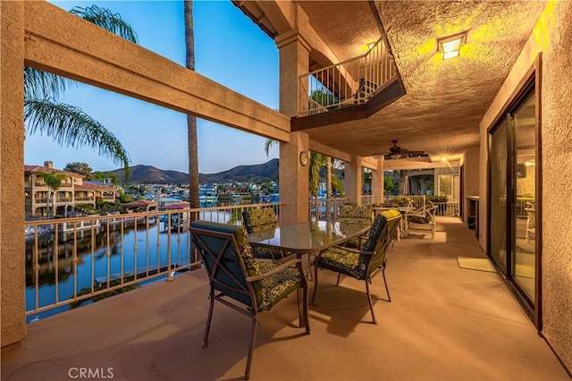 30220 Skippers Way Dr, Canyon Lake, CA 92587 - view of patio with a balcony, a water and mountain view, outdoor dining area, and a ceiling fan