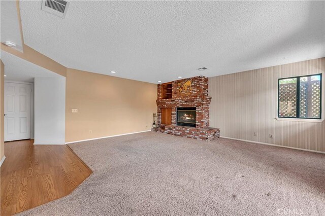 30220 Skippers Way Dr, Canyon Lake, CA 92587 - unfurnished living room with a brick fireplace, a textured ceiling, visible vents, and carpet flooring