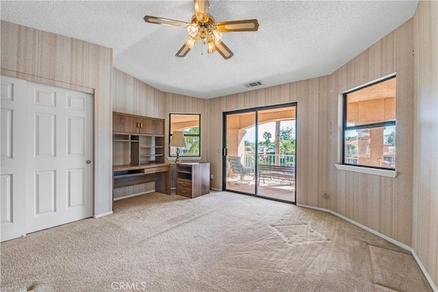 30220 Skippers Way Dr, Canyon Lake, CA 92587 - unfurnished living room with a textured ceiling, ceiling fan, light colored carpet, visible vents, and built in study area