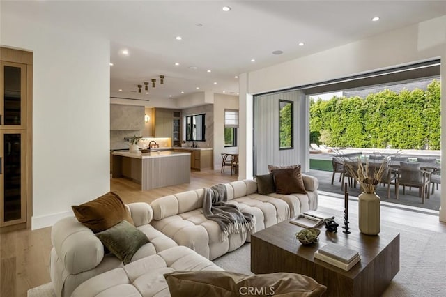 living room with baseboards, light wood-style floors, and recessed lighting