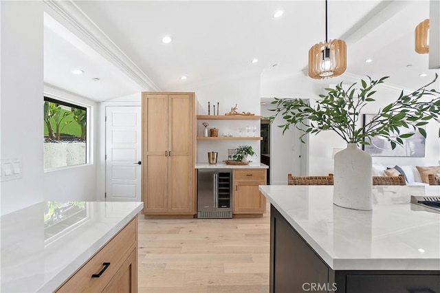 kitchen featuring wine cooler, pendant lighting, lofted ceiling, light brown cabinetry, and light wood-type flooring