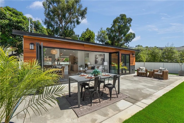 view of patio featuring outdoor dining space, fence, and an outdoor hangout area