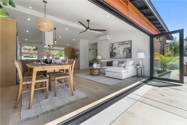 dining area with light wood finished floors, lofted ceiling, recessed lighting, a wall mounted AC, and a ceiling fan