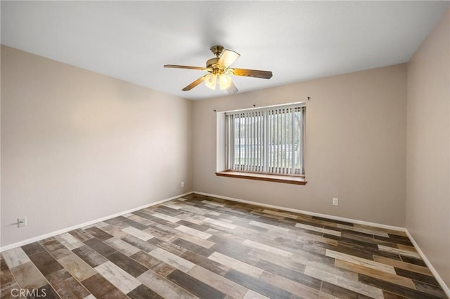 spare room featuring a ceiling fan, baseboards, and wood finished floors