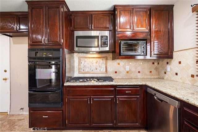 kitchen featuring a warming drawer, appliances with stainless steel finishes, backsplash, and light stone countertops