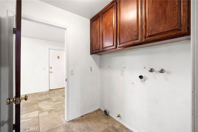 clothes washing area featuring gas dryer hookup, cabinet space, baseboards, and washer hookup