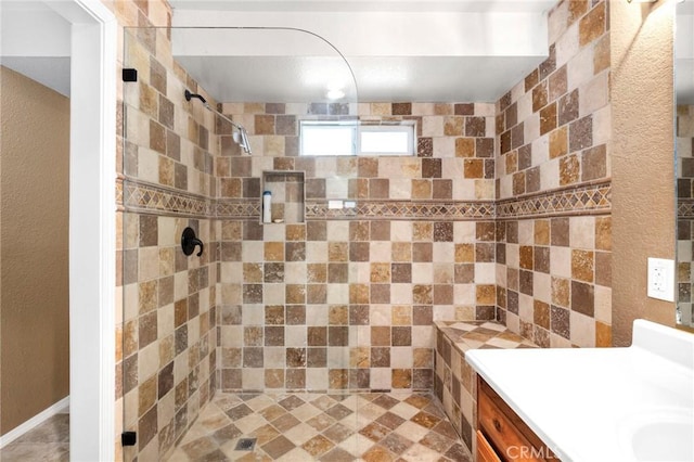 bathroom featuring a tile shower and vanity