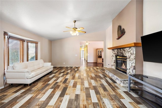 living room with ceiling fan, a fireplace, vaulted ceiling, and wood finished floors