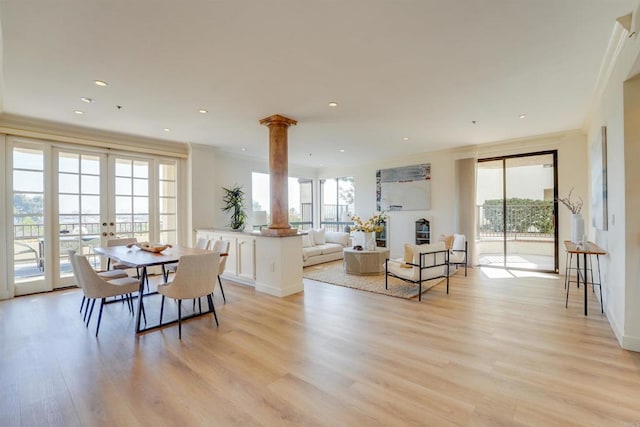 dining space with light wood-type flooring, plenty of natural light, french doors, and decorative columns