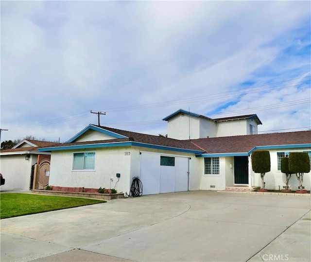 ranch-style home featuring concrete driveway, a front lawn, and stucco siding