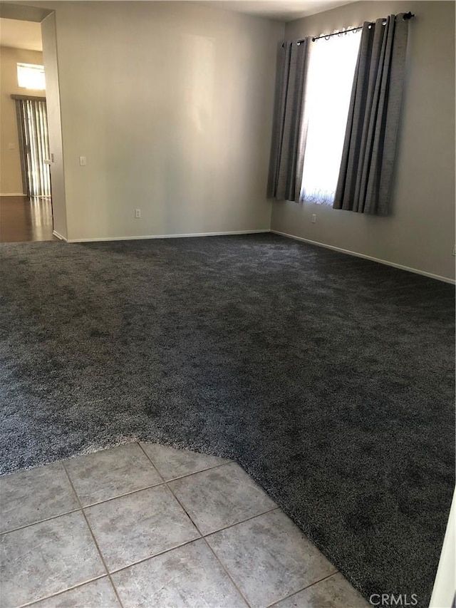 unfurnished room featuring light tile patterned floors and light colored carpet