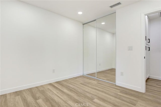 unfurnished bedroom with recessed lighting, visible vents, baseboards, a closet, and light wood finished floors