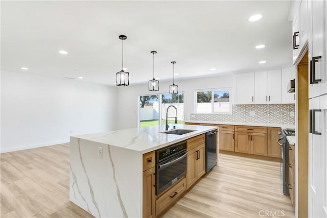 kitchen featuring oven, a sink, white cabinetry, a large island, and stainless steel range