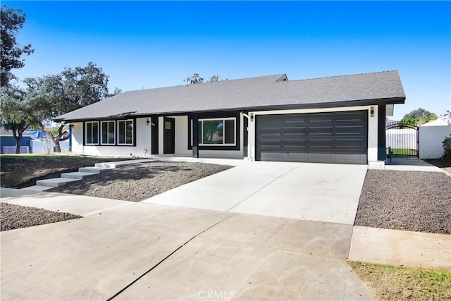 ranch-style house featuring driveway, a garage, a gate, and stucco siding