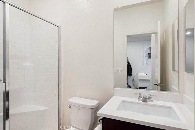 bathroom with vanity, toilet, and a shower stall