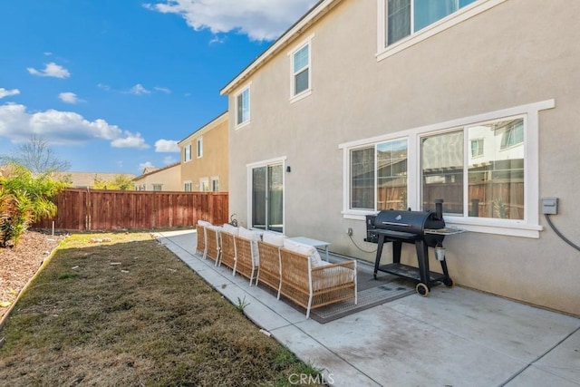 rear view of house with a patio area, fence, outdoor lounge area, and stucco siding