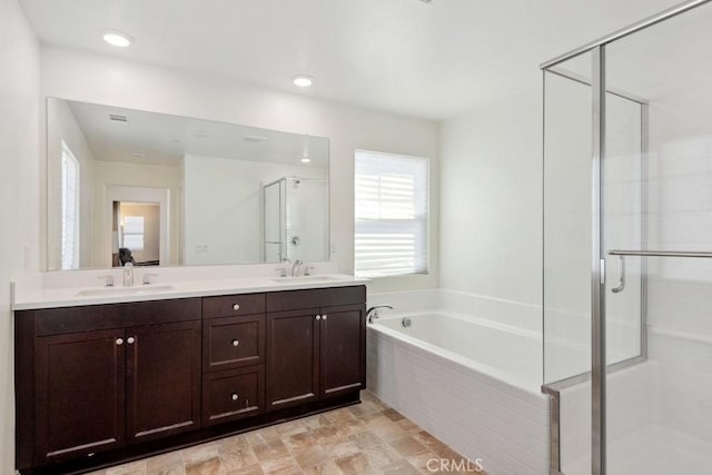 full bath with double vanity, a shower stall, a sink, and a bath