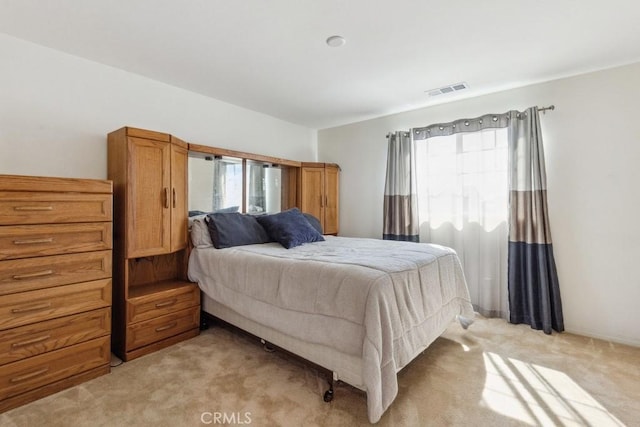 bedroom featuring visible vents and light carpet