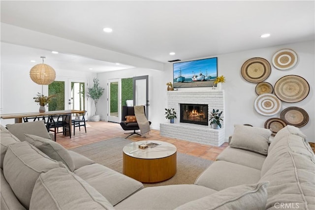 living room with light tile patterned floors, french doors, a fireplace, and recessed lighting