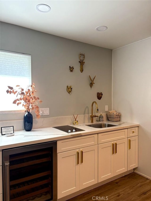 bar featuring dark wood finished floors, beverage cooler, a sink, and black electric cooktop