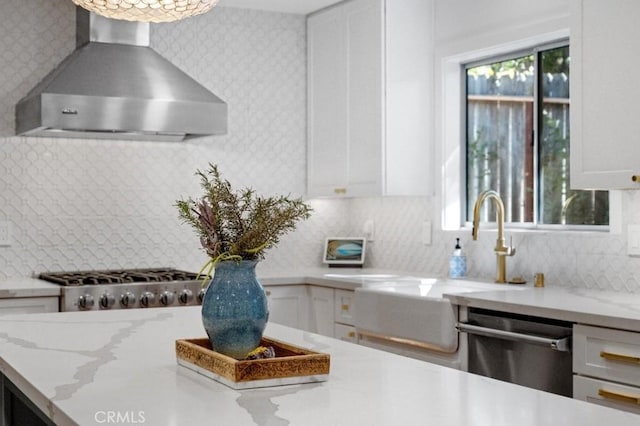 kitchen featuring white cabinetry, wall chimney exhaust hood, appliances with stainless steel finishes, and wallpapered walls