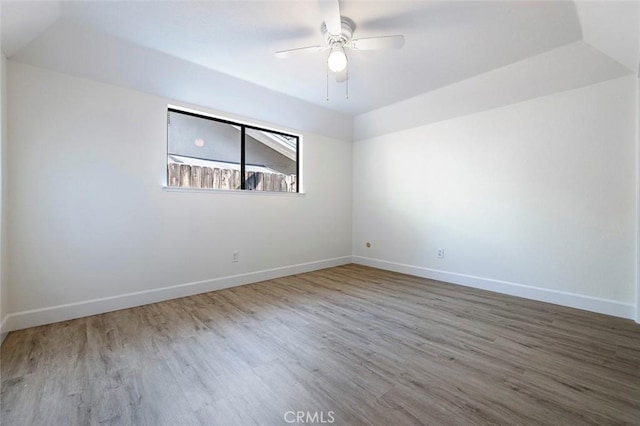 unfurnished room featuring ceiling fan, wood finished floors, and baseboards