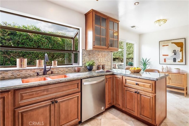 kitchen featuring glass insert cabinets, dishwasher, a sink, and light stone countertops