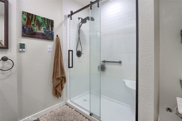 bathroom featuring a stall shower and baseboards