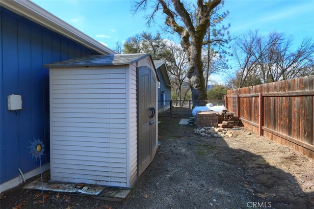 view of yard with an outbuilding, a fenced backyard, and a storage unit