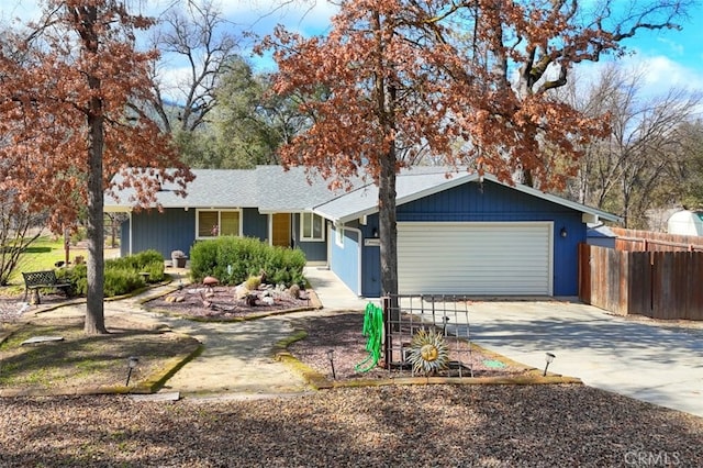 ranch-style house featuring an attached garage, fence, and concrete driveway