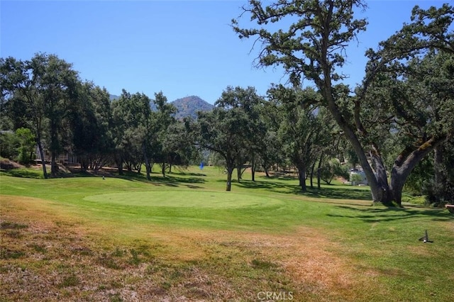 view of property's community featuring a mountain view, golf course view, and a lawn