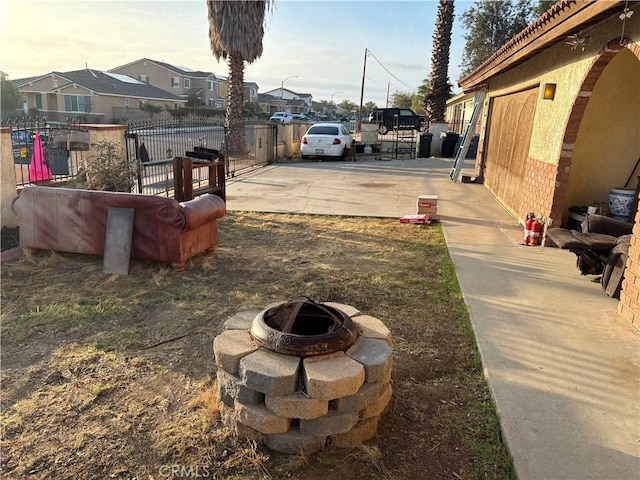 view of yard with an outdoor fire pit, a gate, fence, and a residential view