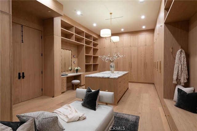 mudroom with light wood-style floors, built in desk, and recessed lighting