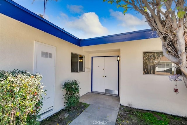 doorway to property with visible vents and stucco siding