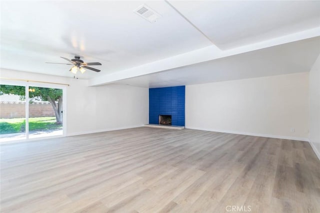 unfurnished living room featuring visible vents, baseboards, a fireplace, ceiling fan, and light wood-style floors