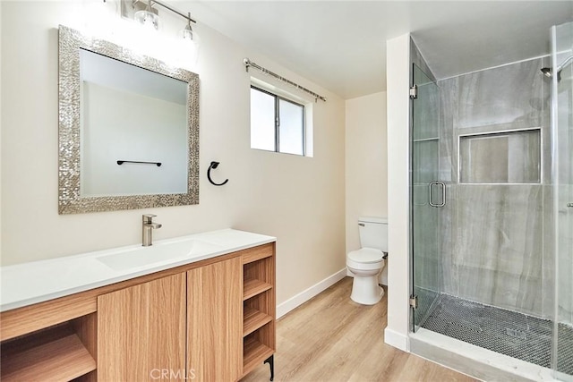 full bathroom featuring vanity, wood finished floors, baseboards, a stall shower, and toilet