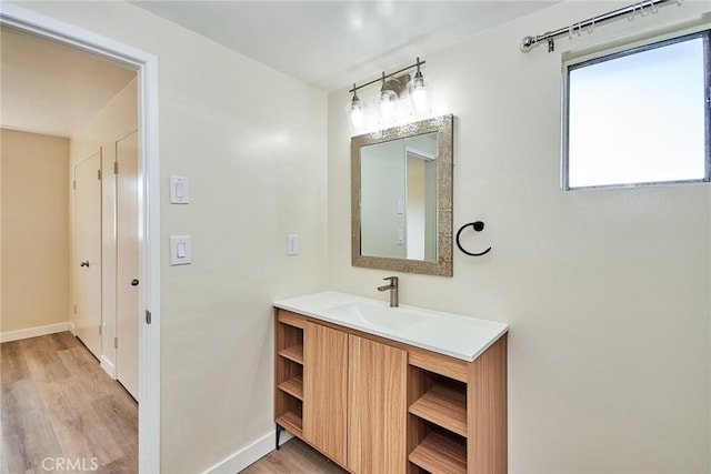 bathroom with vanity, baseboards, and wood finished floors