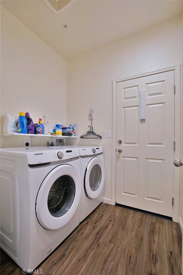 laundry room with laundry area, dark wood-type flooring, washer and clothes dryer, and baseboards