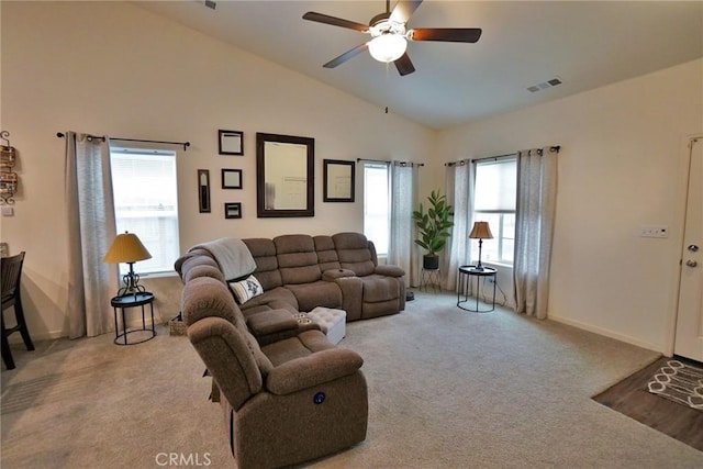 carpeted living area with high vaulted ceiling, visible vents, ceiling fan, and baseboards