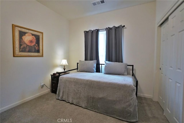 bedroom with carpet floors, baseboards, visible vents, and a closet