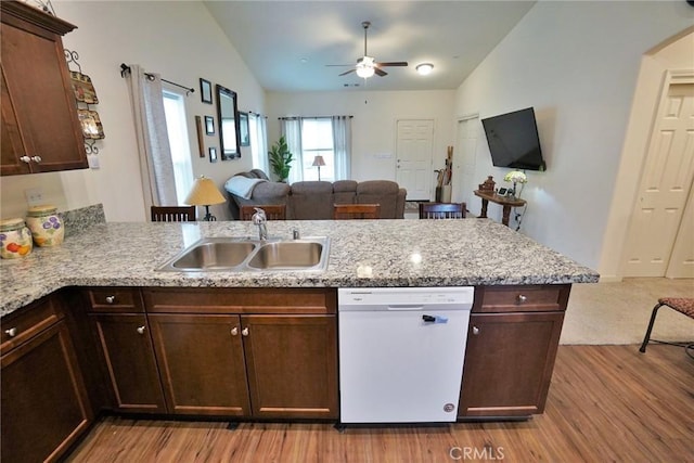 kitchen featuring open floor plan, dishwasher, a peninsula, and a sink