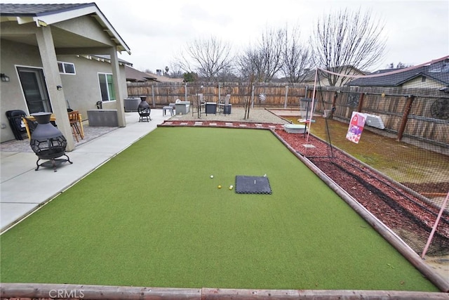 view of community with an outdoor fire pit, a patio area, and a fenced backyard