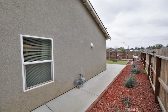 view of home's exterior featuring a fenced backyard, a patio, and stucco siding