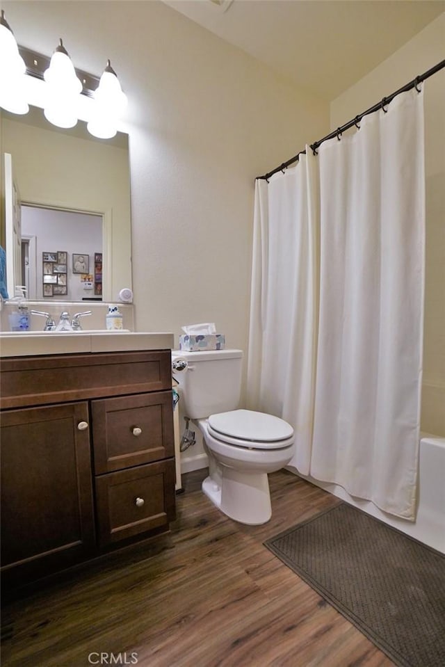 full bathroom with vanity, shower / tub combo, wood finished floors, and toilet