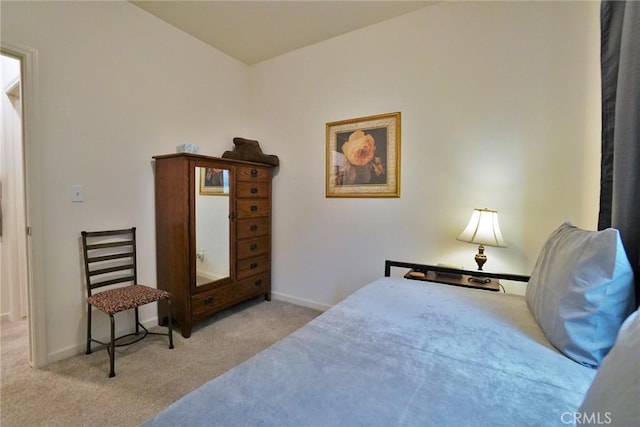 bedroom featuring light carpet and baseboards