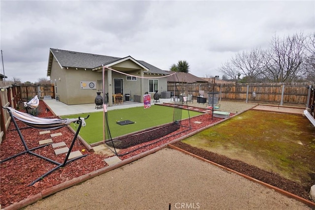 back of house featuring a fenced backyard, a patio, and stucco siding